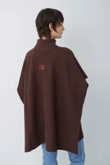 Poncho de tejido de punto color caramelo con cuello alto y diseño holgado sin mangas.