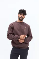 Buzo de algodón azul marino, corte regular, con cuello redondo. Presenta un bordado de flores y texto en el pecho.