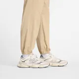 Pantalón cargo New Balance color beige, con cintura elástica, bolsillos laterales tipo cargo y puños elásticos en los tobillos.