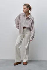 Camisa de viscosa color celeste, de calce amplio y caída fluida, con cuello clásico, cierre frontal de botones y detalles calados en mangas y delantero.