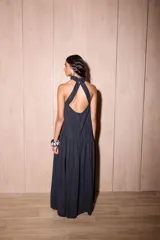 Vestido largo negro de crepe texturado con escote halter, cuello alto con volados y diseño holgado.