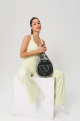 Conjunto deportivo de dos piezas en color amarillo limón, compuesto por un top de escote redondo con espalda estilo nadadora y un pantalón de corte acampanado con cintura alta.