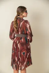 Vestido midi estampado con diseño abstracto en tonos marrones, verdes y blancos. Modelo cruzado con falda plisada y cintura elastizada.