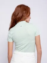 Remera corta color amarillo con estampado de lunares blancos, cuello alto y mangas cortas.