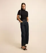 Blusa de corte regular confeccionada en tejido de rib acanalado color naranja. Presenta cuello alto y mangas cortas.