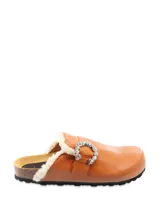 Sueco de cuero color marrón, con forro de piel sintética blanca y hebilla decorativa con apliques de strass.