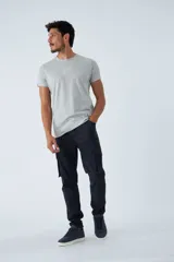 Pantalón cargo de corte slim, color verde militar, con cierre frontal, botón en la cintura, pasacintos y bolsillos laterales con solapa y botones.