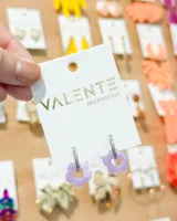 Aros colgantes con aro de acero plateado y dije de flor lila de acrílico.