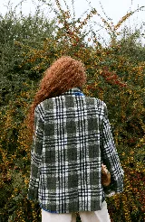 Blazer sastrero de corte oversize, con cuello solapa, manga larga y cierre frontal con botones. Presenta un diseño a cuadros en tonos bordó y blanco, con detalles de costuras bordadas en hilo amarillo en los bolsillos y el ruedo. Incluye forro interior de satén.