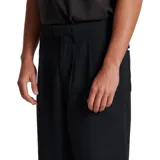 Pantalón negro de tela twill, con pinzas frontales, cierre de botón y cremallera, y corte recto.