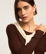 Suéter de punto acanalado color beige, con cuello redondo y mangas largas. Confeccionado en tejido tricot con textura suave y ajuste al cuerpo.