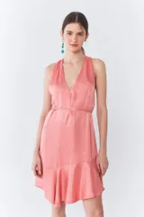 Vestido corto color durazno, con escote halter, espalda descubierta, volado asimétrico en el ruedo y lazo para ajustar en la cintura.