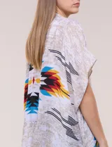 Kimono de gasa ligera con diseño estampado tribal en tonos beige, azul, rojo y amarillo, de silueta amplia y mangas cortas holgadas.