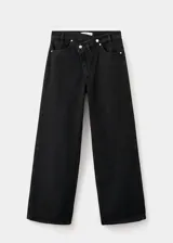 Pantalón de jean estilo wide leg con cintura cruzada y cierre frontal asimétrico. Cuenta con cinco bolsillos y trabillas para cinturón.