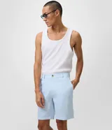 Bermuda masculina de corte slim, color celeste, confeccionada en tejido texturizado de lino y algodón. Cuenta con cintura fija con trabillas, cierre delantero con botón y cremallera, y bolsillos.