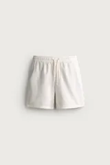 Bermuda relaxed fit de tejido de algodón color blanco, con cintura elástica ajustable con cordón y bolsillos laterales.