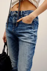 Pantalón de jean de corte recto y tiro medio con efecto acid wash y roturas sutiles en los bolsillos traseros.