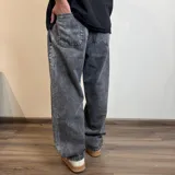 Pantalón jean negro de corte ancho.