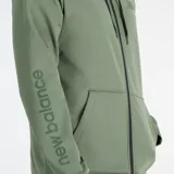 Campera deportiva New Balance Tenacity color verde oliva, con cierre frontal completo, capucha con cordón ajustable, bolsillos laterales abiertos y logo de la marca en el pecho y en la manga izquierda.