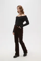 Pantalon de corte flare y tiro alto, confeccionado en tejido de pana color marrón oscuro, con cierre frontal y bolsillos laterales.
