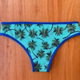Bombacha vedetina estampada con palmeras, forrada adelante y atrás, con ribete azul.