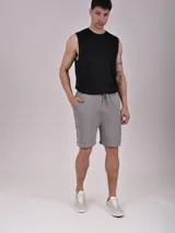 Bermuda gris de algodón con cintura elástica ajustable con cordón y bolsillos laterales con cierre.