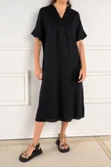Túnica midi de color negro, con escote en V, mangas cortas y corte holgado. Confeccionada en una mezcla de viscosa y lino, ofrece una caída ligera y cómoda.