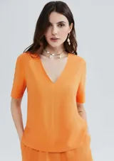 Blusa naranja de lino con escote en V y mangas cortas.