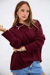 Sweater de tejido de punto acanalado en color bordó, con cuello redondo y mangas largas. Presenta un corte holgado y cómodo.