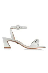 Sandalia de cuero blanca con tira delantera con nudo, tira al tobillo con hebilla y taco geométrico.