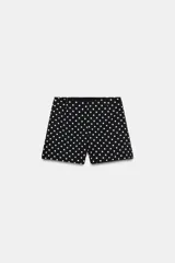 Shorts negros de tiro alto con estampado de lunares blancos, corte clásico y cierre lateral oculto.