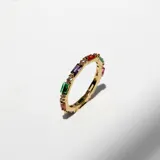 Anillo dorado con cristales multicolores rectangulares.