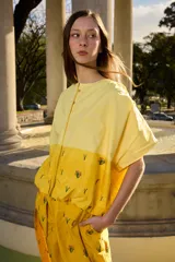 Camisa amarilla de manga corta con botones en la parte delantera y delicados bordados florales repartidos en la prenda.