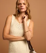 Vestido midi de punto texturizado color beige, sin mangas y con cuello redondo.