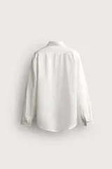 Camisa celeste de lino de corte regular fit, con cuello abotonado, manga larga y cierre frontal de botonadura.
