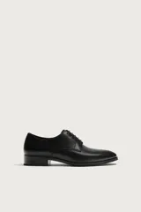 Zapato de vestir tipo derby en color negro, con diseño de parte superior lisa, horma redonda y suela con ligero tacón.