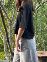 Blusa color beige de viscosa elastizada, con cuello bote y espalda cruzada. Estampado frontal con ilustración de una cara con corona de flores.