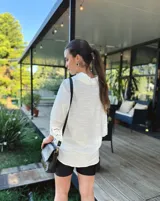 Cartera bandolera de cuero negro con textura tipo cocodrilo, correa larga regulable y forro interno de tela.