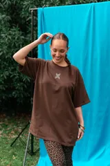 Remeron de algodón color marrón, de corte oversize, con mangas cortas y pequeño estampado en el pecho.