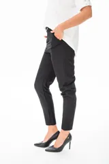 Pantalón de vestir negro con corte slim, tiro alto y cinturón con hebilla metálica.