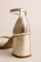 Sandalia de tacón cuadrado medio, confeccionada en tela tipo terciopelo color bordó, con tira delantera simple y pulsera ajustable al tobillo con hebilla metálica.