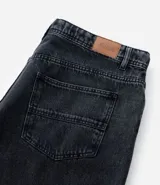 Pantalón wide leg de jean con efecto marmorizado, de tiro alto, con bolsillos laterales y cierre frontal con botón y cremallera.