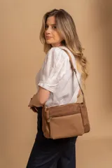 Bandolera de diseño práctico y moderno, confeccionada en una combinación de tela y cuero sintético. Cuenta con un compartimento principal con cierre, un bolsillo frontal con cierre y una correa regulable para llevar al hombro o cruzada.