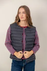 Chaleco acolchado de nylon color negro, con cierre frontal de botones a presión y cuello redondo.