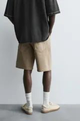 Bermuda de denim de algodón, color verde claro lavado, de corte recto y tiro medio. Presenta cinco bolsillos y cierre frontal con cremallera y botón.