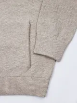 Campera de lana con cierre frontal completo, cuello alto y logo bordado en el pecho. Presenta un diseño de tejido de punto texturizado.
