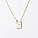 Collar con cadena dorada y dije rectangular blanco con borde dorado y cruz dorada en el centro.