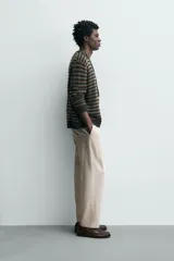 Pantalón de corte relajado confeccionado en una mezcla de algodón y lino. Presenta cintura elástica con cordón ajustable, bolsillos laterales y bolsillos traseros de vivo.