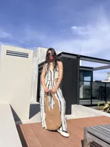 Conjunto de dos piezas compuesto por un top halter con escote en V y un pantalón de corte recto y tiro alto. Ambas prendas presentan un estampado vertical de puntos negros sobre fondo blanco.