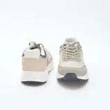 Zapatillas de running confeccionadas en una combinación de malla y ante, con diseño tricolor en tonos gris, beige y blanco. Presentan cordones al tono y suela de goma con refuerzo en la puntera.